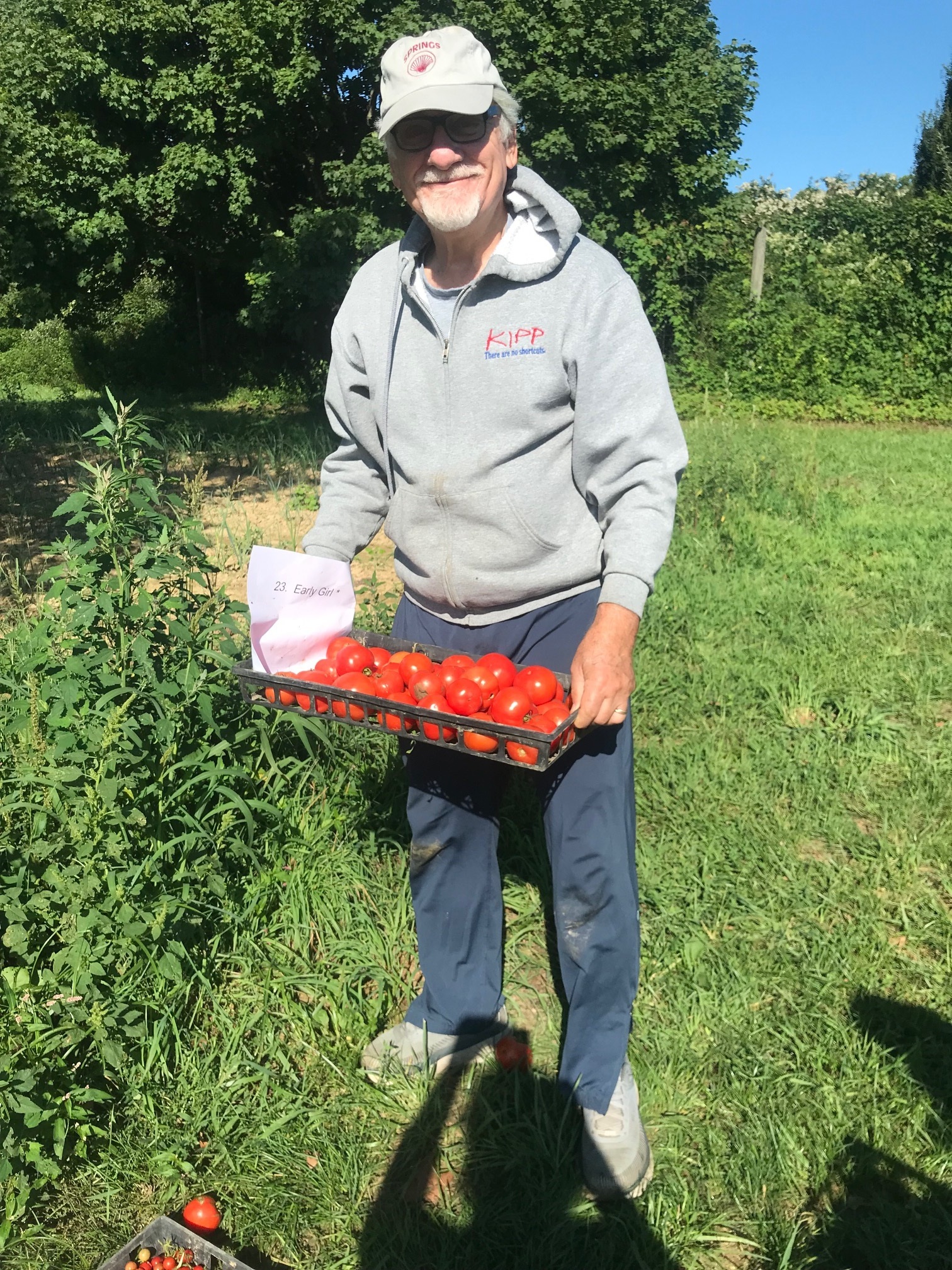 man holding crate of tomatoes