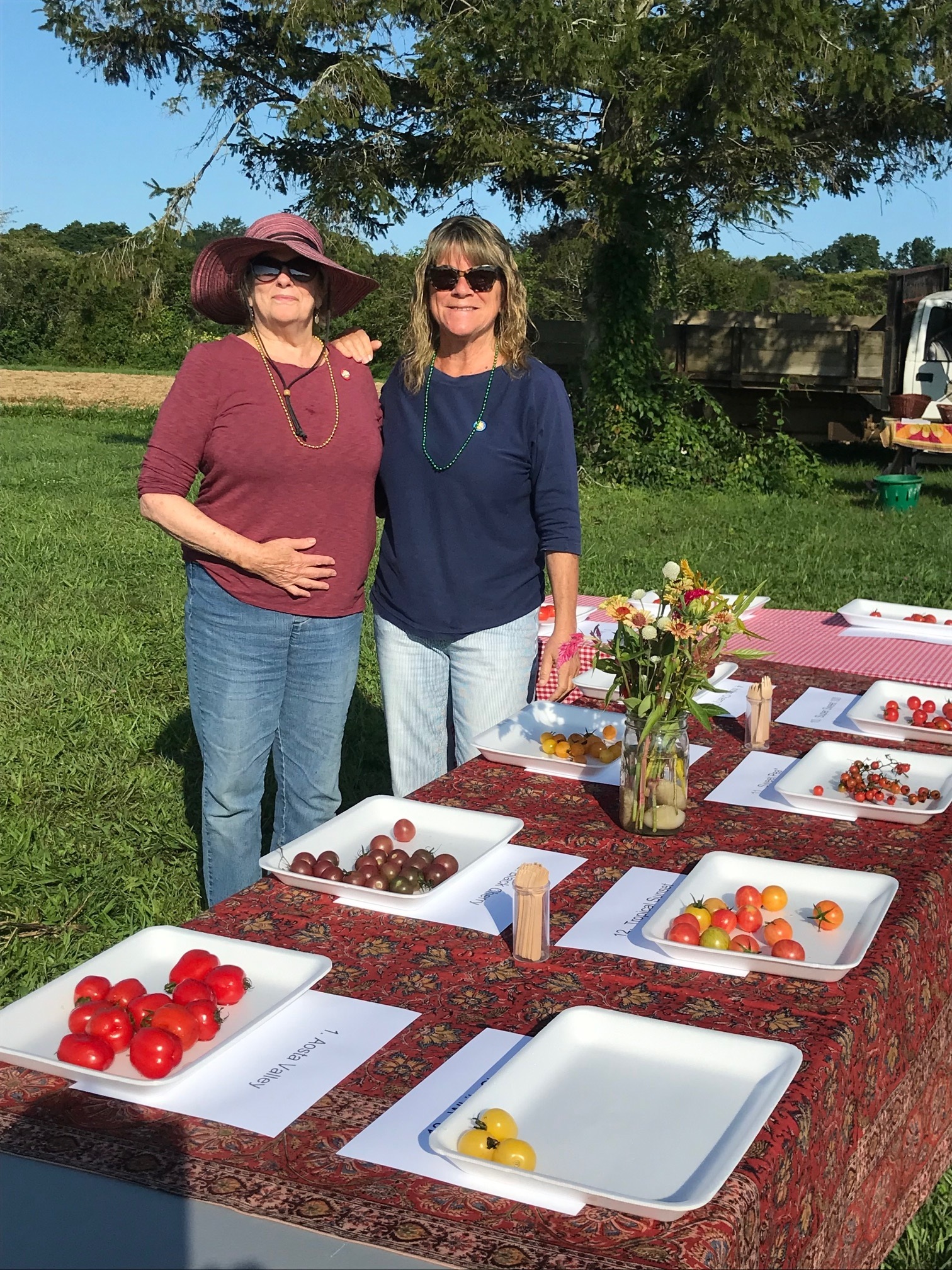 two women in front of tomato table