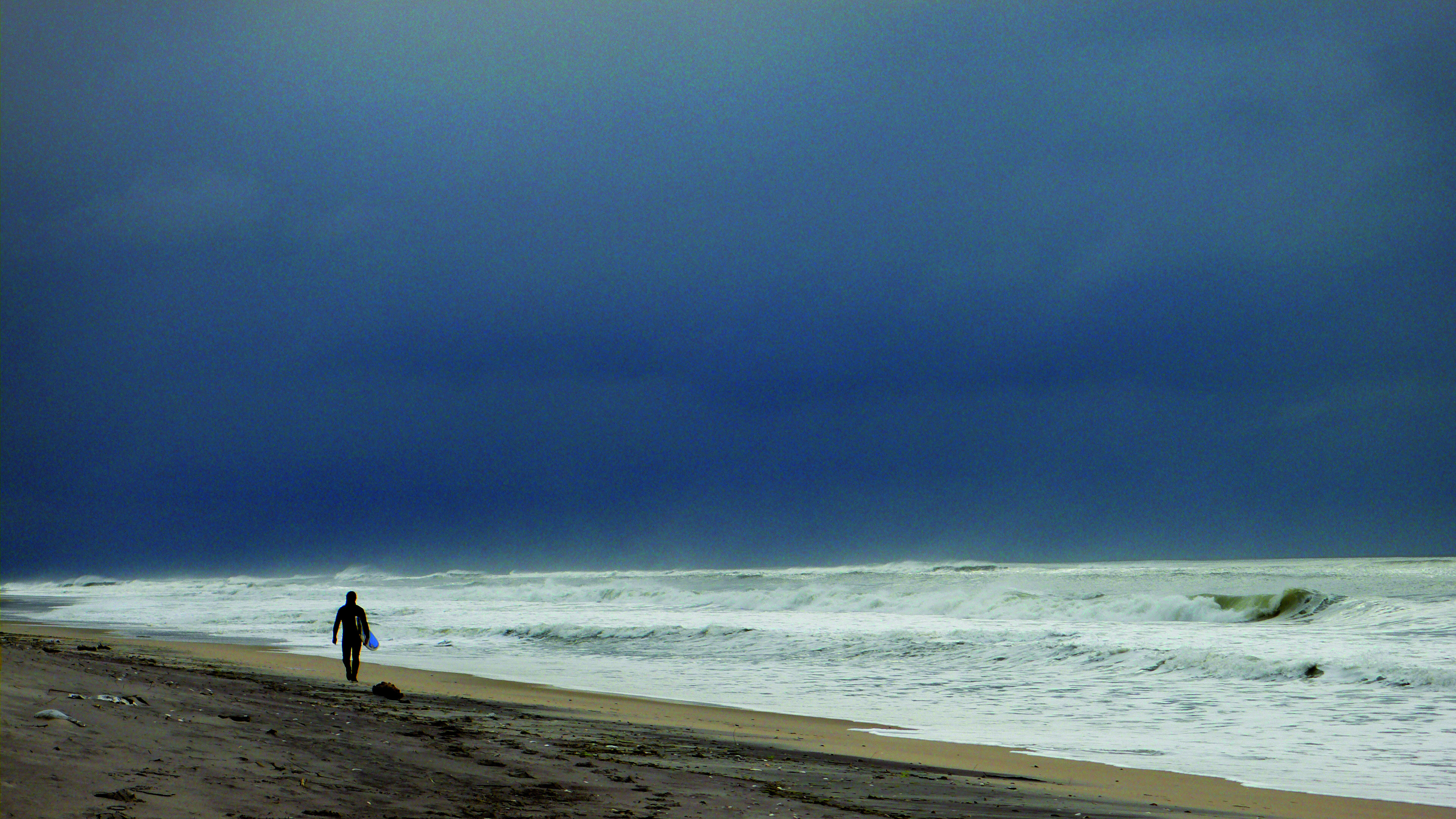 person walking alongside the ocean