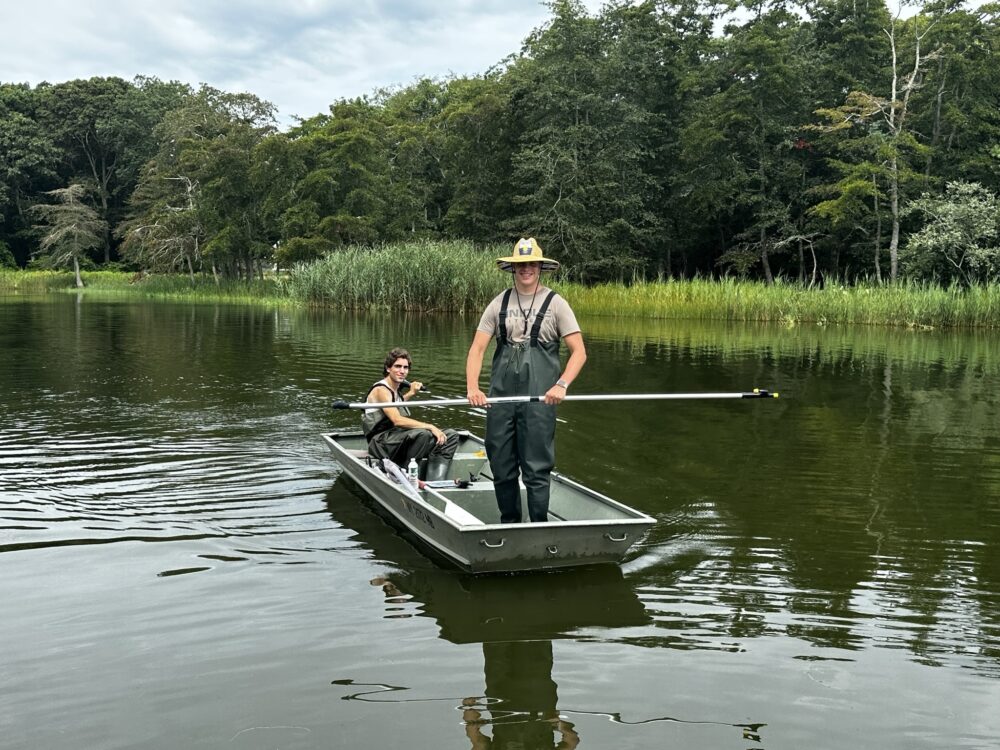 staff on boat in the pond