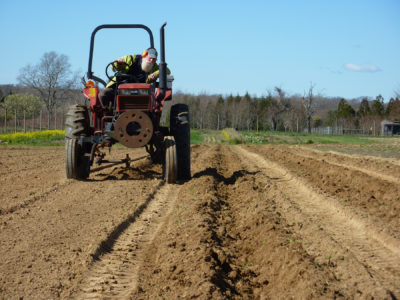 A tractor being driven  on a farm field
